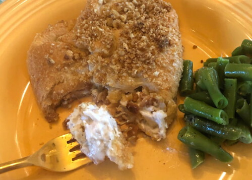 Time to enjoy a golden brown crescent roll chicken bundle with green beans on the side.