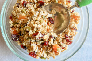 A bowl full of granola with a scoop.