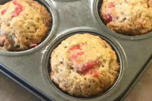 Baked banana cherry muffins in a muffin tin.