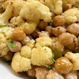 A serving of roasted cauliflower and chickpeas with mustard vinaigrette.