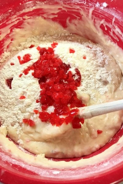 Banana bread batter with dry ingredients and cherries.