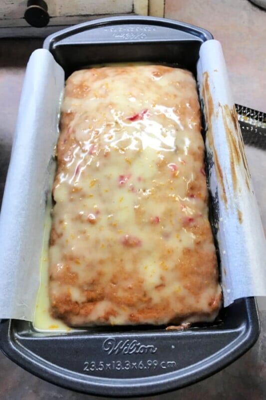 Banana bread loaf with orange glaze on top.