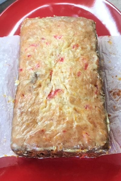 Whole unsliced loaf of banana bread on a red platter.