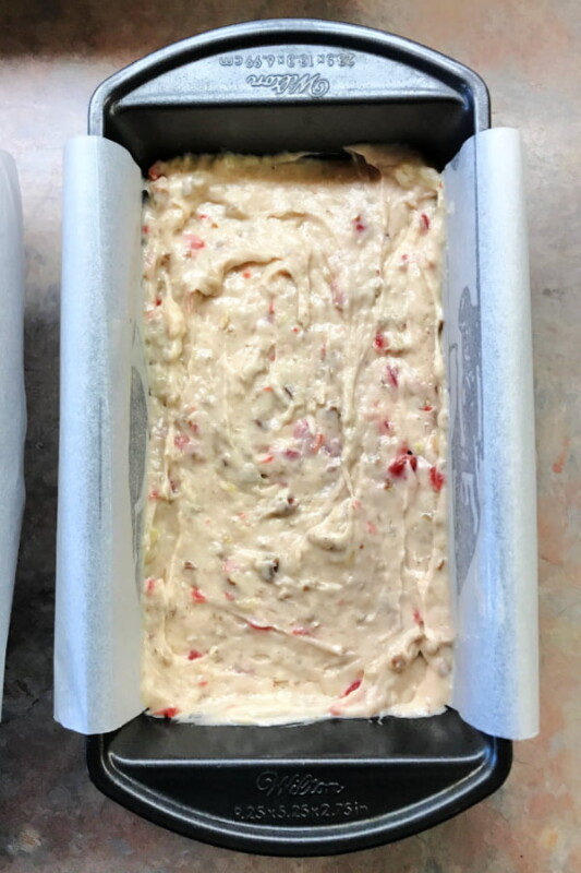 Loaf pan full of banana bread batter that is smoothed out on top.