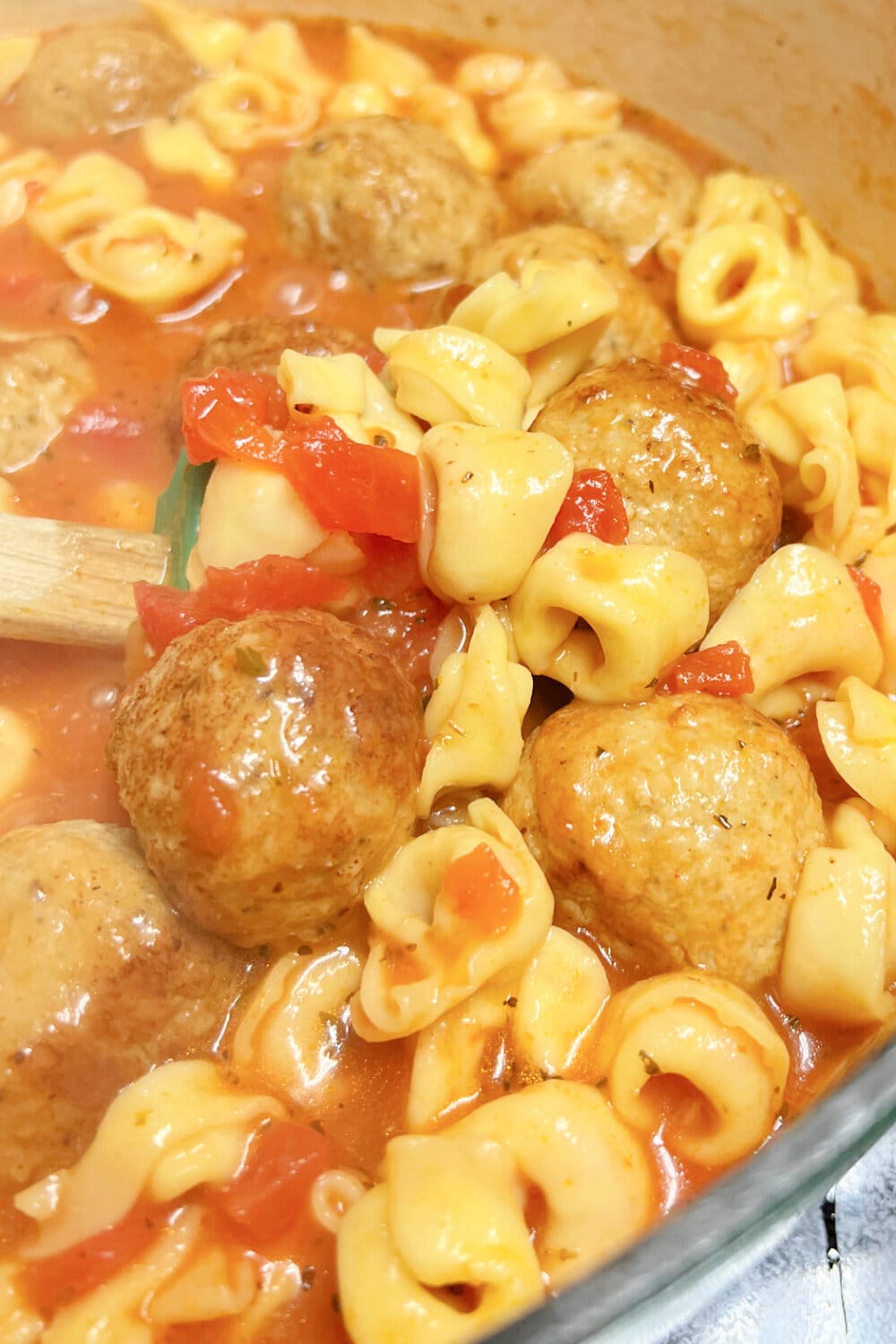 A big, steaming pot of cheese tortellini and meatball soup. 