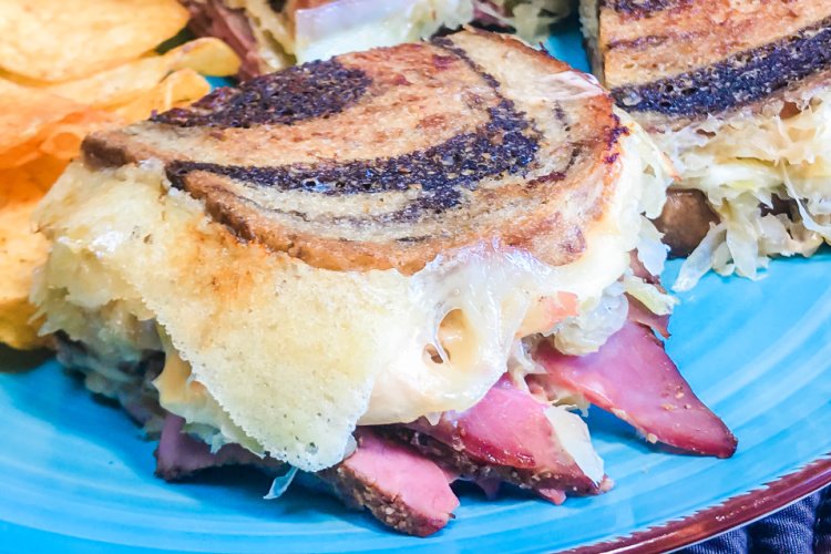 Side view of a grilled Reuben sandwich.