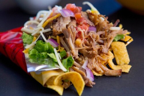 Pulled Pork Walking Tacos are classic Midwestern fare that you'll find at the State Fair - the home of all THE BEST portable foods!  Instead of using chili in this recipe, we've paired crunchy Fritos corn chips (right in the bag, of course!) with pulled pork, salsa, lettuce, sour cream, and fresh cilantro....add a heaping of  the fresh ingredients you enjoy most.