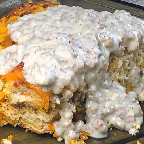 A piece of breakfast casserole with sausage gravy on top.