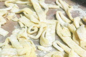 Homemade egg noodles spread out on the counter.