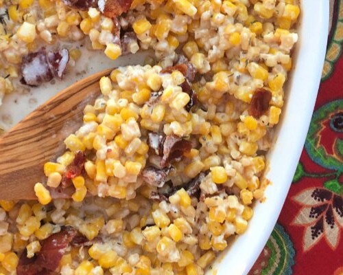 A creamy corn casserole topped with bacon and baked in a cast iron skillet or casserole dish.