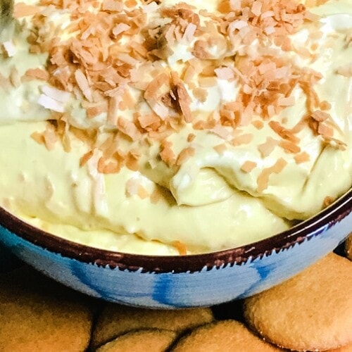 A bowl of coconut cream pie dip with vanilla wafers.