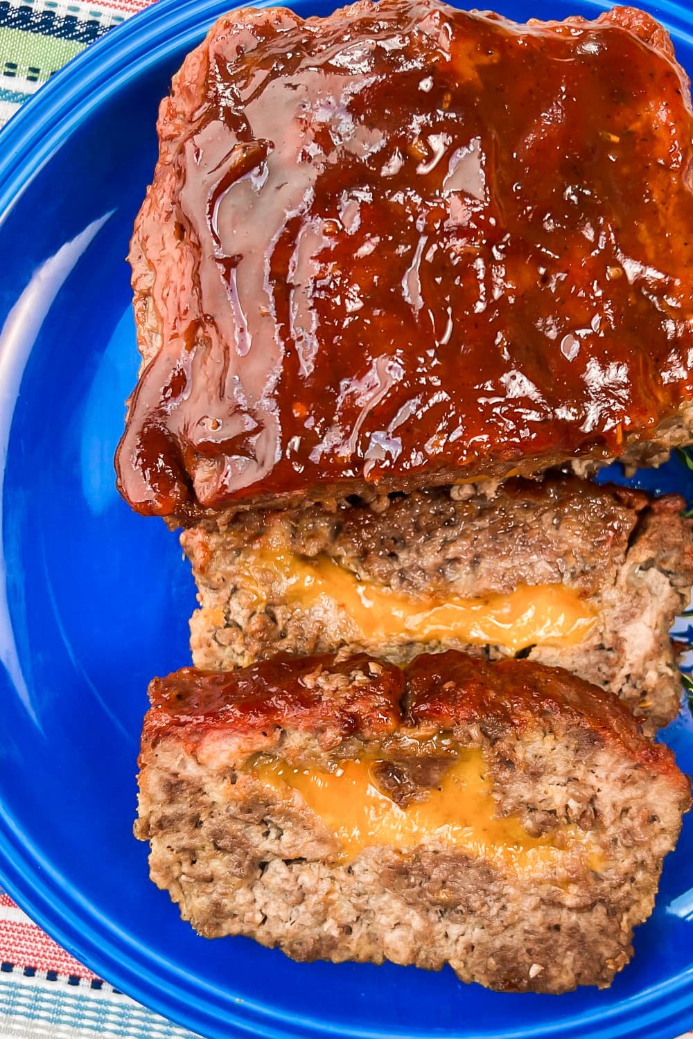 Sliced smoked whiskey-barbecue meatloaf on a blue platter.