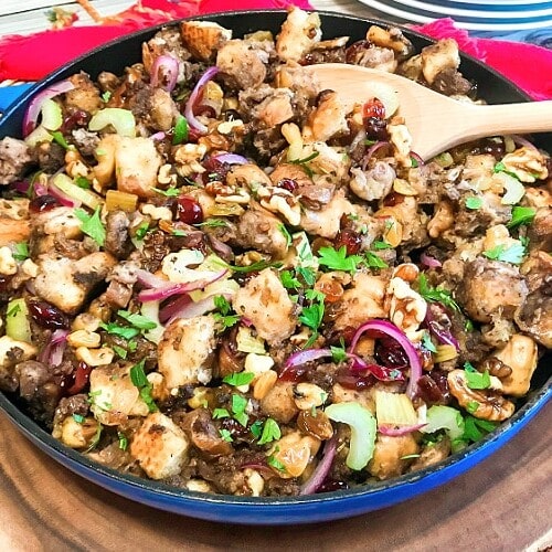 A blue skillet full of cranberry walnut sausage stuffing.