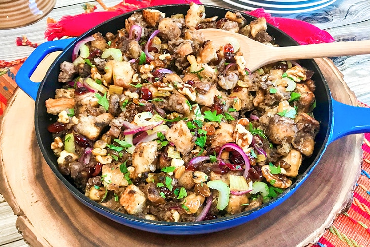 A blue skillet full of cranberry walnut sausage stuffing.
