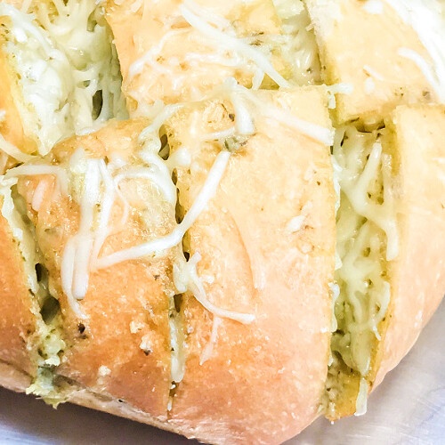 A loaf of cheesy pull-apart pesto bread, hot from the oven.
