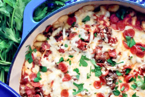 A blue skillet full of meat lovers gnocchi bake.