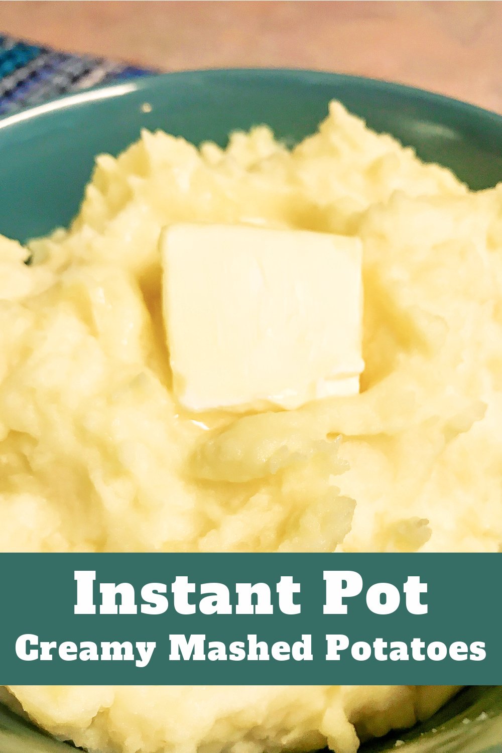 A bowl loaded with creamy mashed potatoes with a melting pat of butter on top.