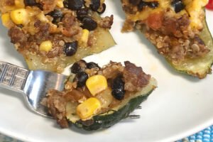 A big forkful of zucchini burrito boats with Mexican sausage filling.