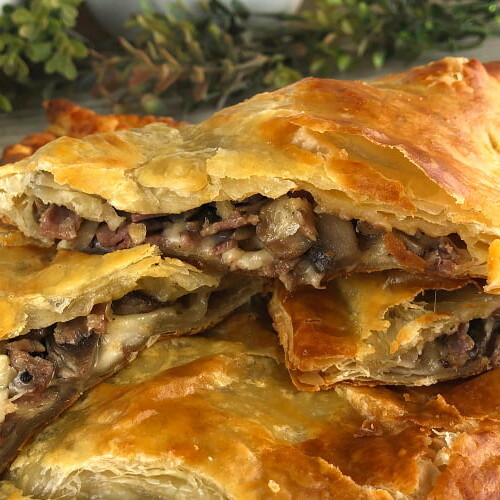 Puff Pastry Roast Beef Packets stacked on a platter.