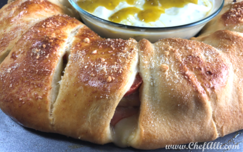 This Spicy Italian Crescent Ring is a great way to serve a crowd. It's loaded with all of your favorite Italian sub flavors, then baked in buttery, flaky crescent roll dough. I like to serve it with a good dollop of mayonnaise and Sarah Jane's Jalapeno Mustard. Yum! #crescentring #ItalianSubRecipe #SarahJanes