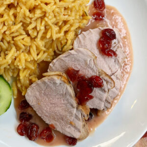 Pork tenderloin medallions on a white plate.