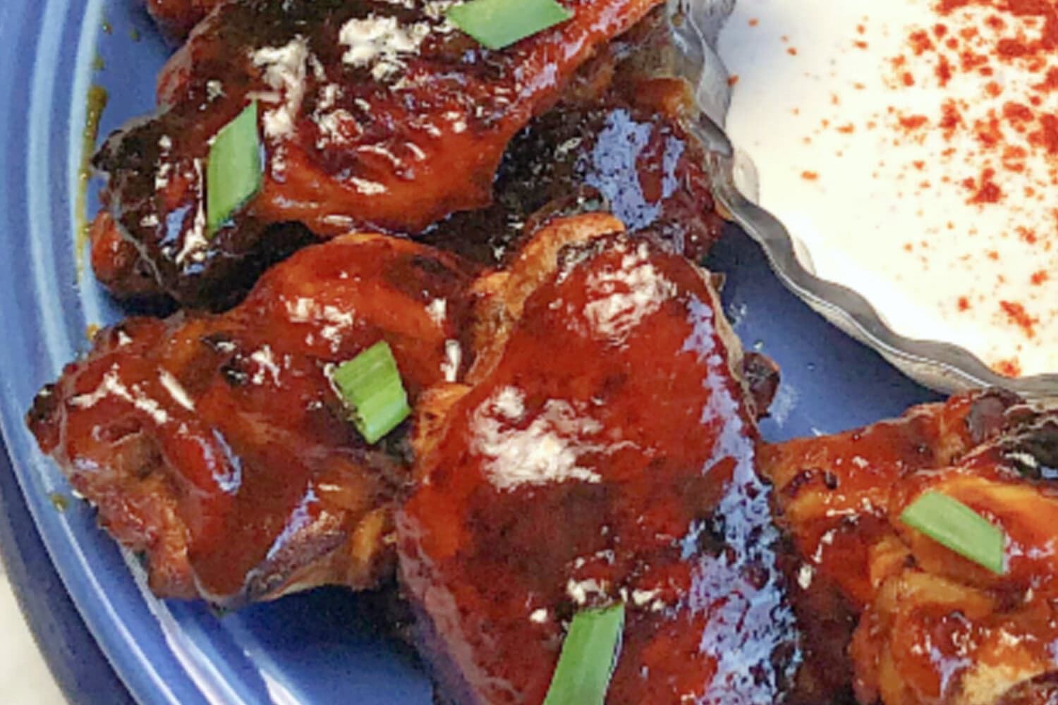 instant-pot-honey-bbq-wings-plate Instant Pot honey BBQ Chicken Wings on a blue plate with dipping sauce.