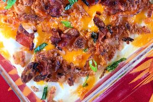 A 9 x 13 pan of of mashed potatoes topped with bacon, cheese, and french fried onions.