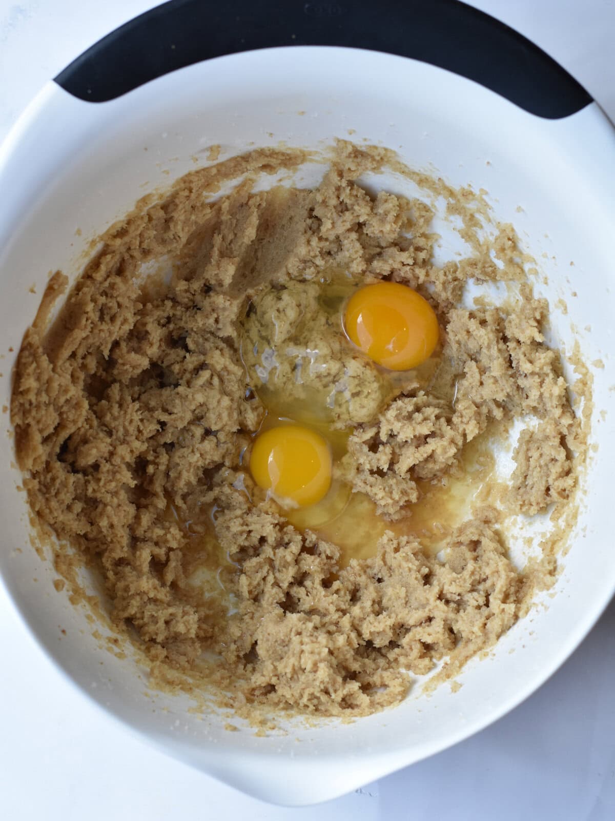 Batter with eggs in a white bowl. 