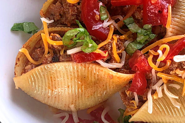 Here's a rock-solid ground beef recipe for your clan! My guys love this Cheeseburger-Stuffed Jumbo Pasta Shells casserole and I serve it up year round for them.  All the ingredients are likely already on hand in your pantry and you can throw this ground beef dish together in nothing flat. I love to make this recipe in my favorite cast iron skillet.  #speedymeal #groundbeef #casserole #skilletmeal