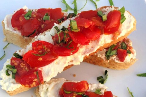 Who knows how many times we've made this easy appetizer when there's tons of homegrown tomatoes coming in from the garden! These Tomato Crostini combine the crispy/chewy texture of the bread with the creamy feta spread and the luscious vine-ripened tomatoes with fresh basil.  #HomegrownTomatoes #Tomatoes #Basil #Appetizer #Feta