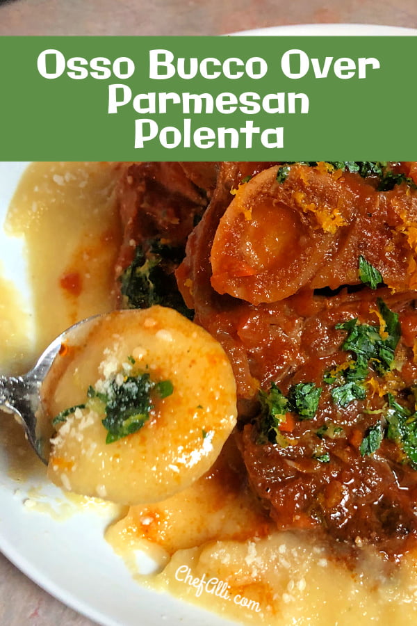 A braised pork shank Osso Bucco with sauce on a bed of parmesan polenta, garnished with gremolata.