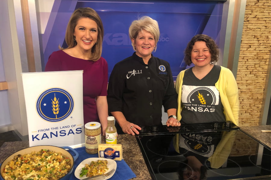 From the Land of Kansas photo featuring three people at a cooking island with a breakfast skillet and products.