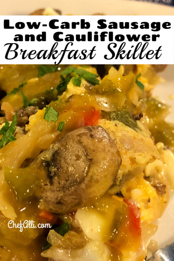 An up-close shot of a low-carb sausage and cauliflower breakfast skillet, featuring eggs and lots of vegetables.