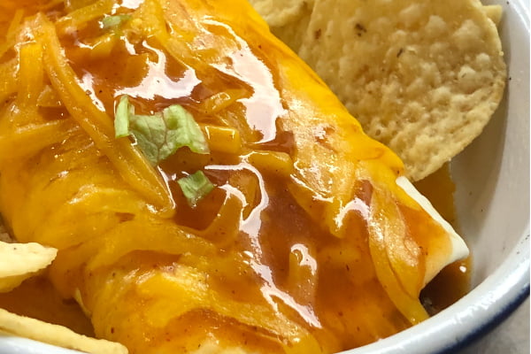 sanchilada with enchilada sauce, cheese, and tortilla chips.