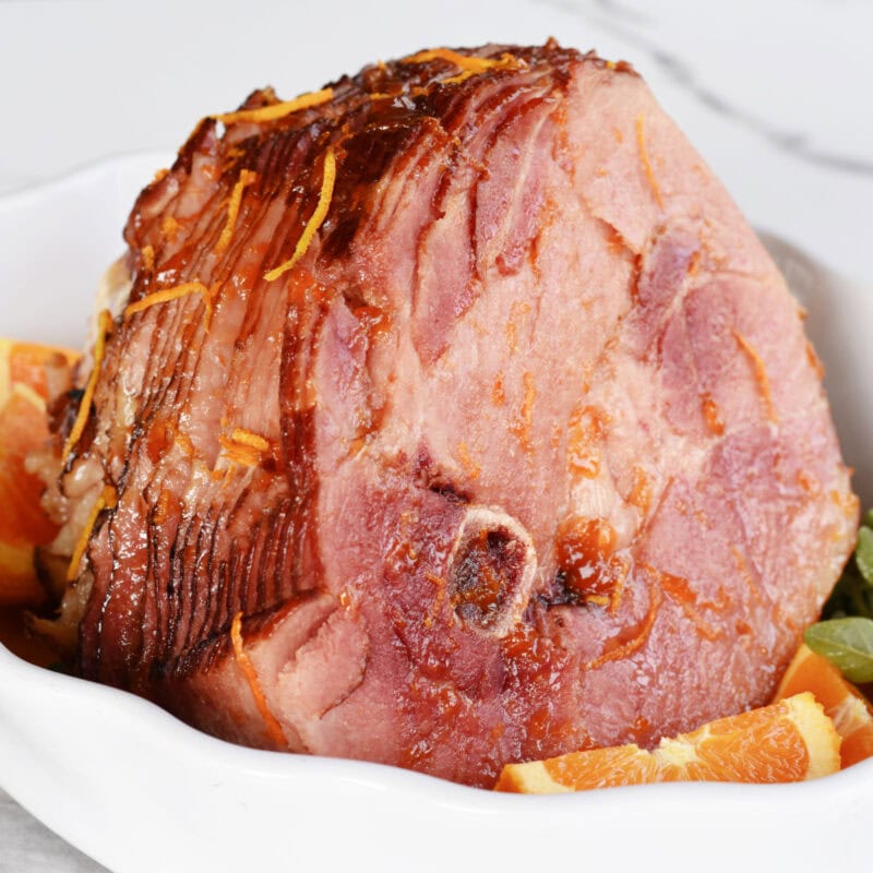 A spiral ham in a white serving dish.