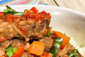 Beef Swiss Steak with veggies and gravy in a bowl.