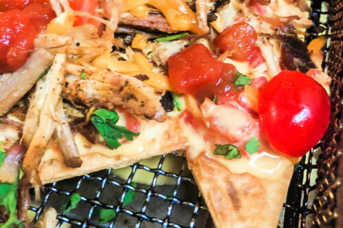 Baked flour tortilla chips topped with pork and queso.