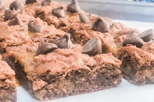 Side shot of Caramel Fat Boy Brownies topped with lots of chocolate chips.