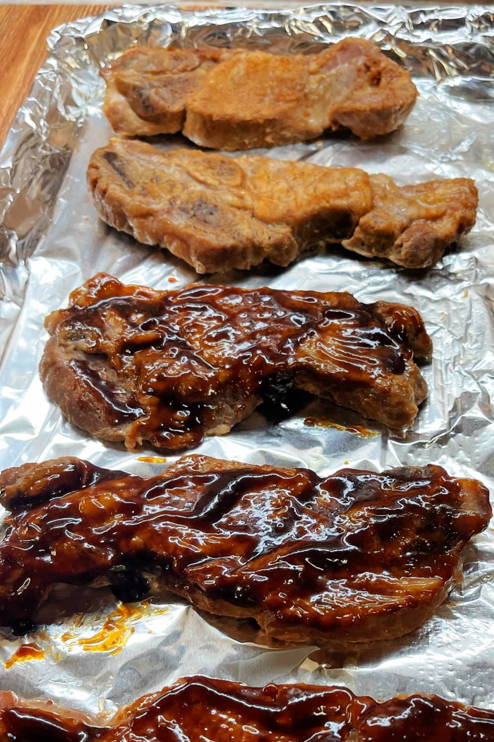 Country-style ribs that have partially been brushed with sauce. 