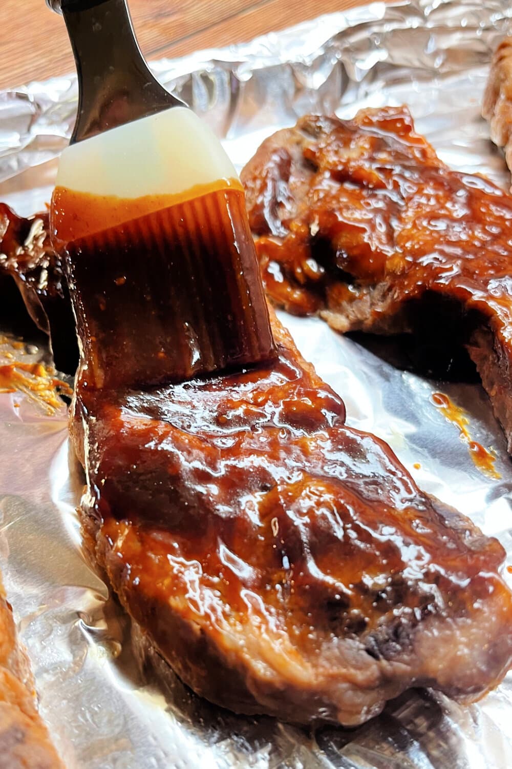 Basting ribs with barbecue sauce using a silicone pastry brush .