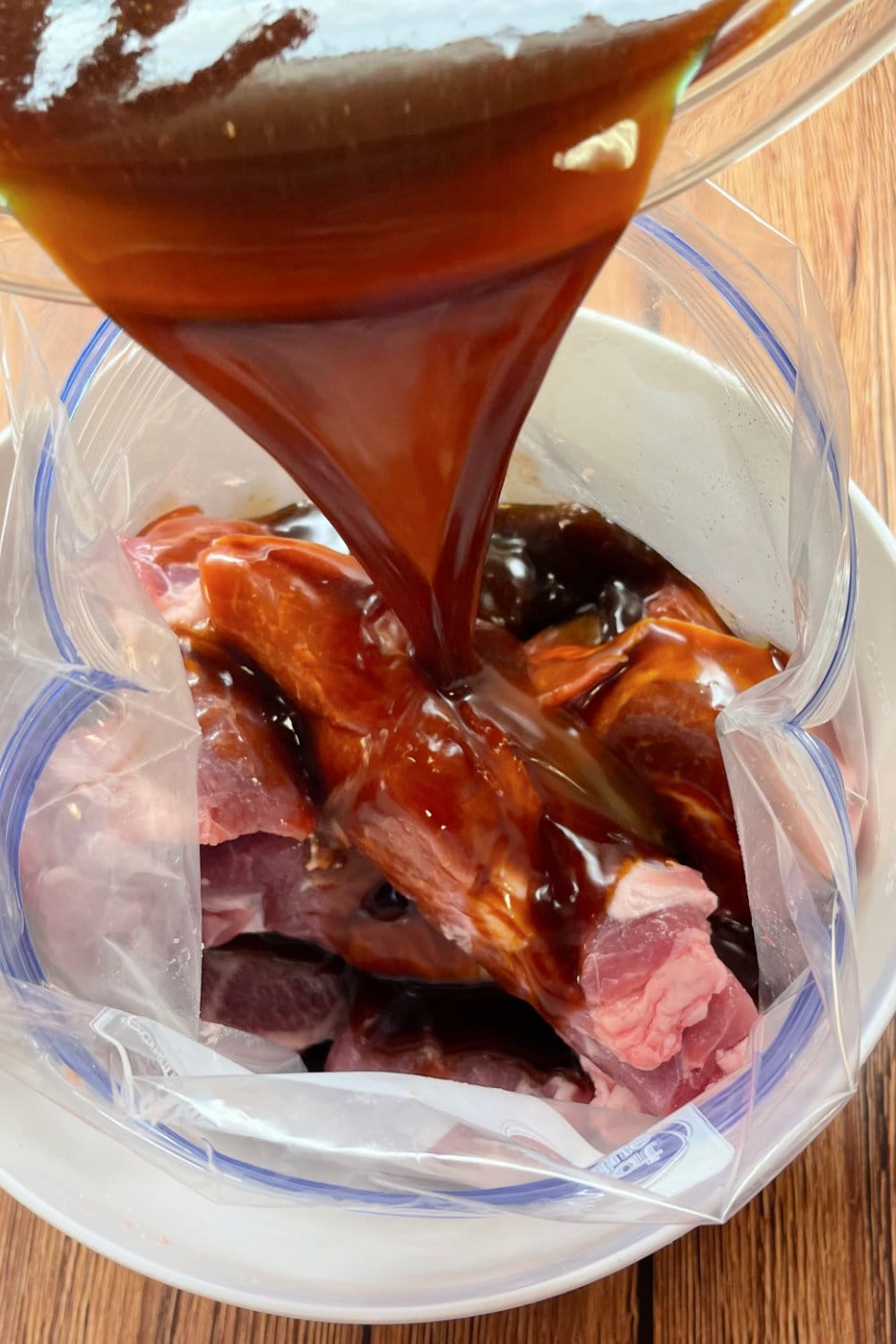 Pouring the marinade into the bag of ribs. 