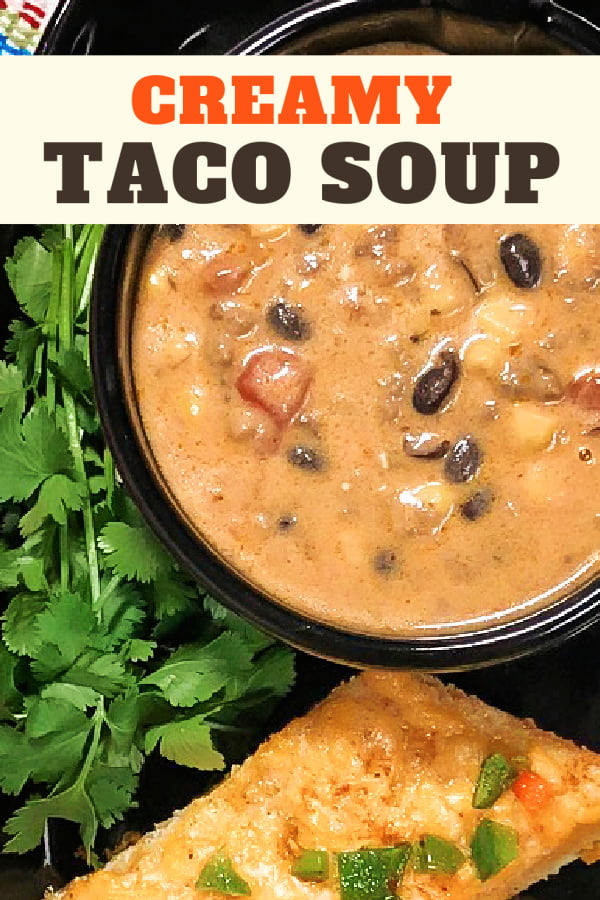 A bowl of creamy taco soup alongside a slice of Mexican cheese bread. 