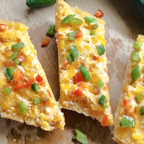 Piled high slices of Mexican Cheese Bread on a cutting board.