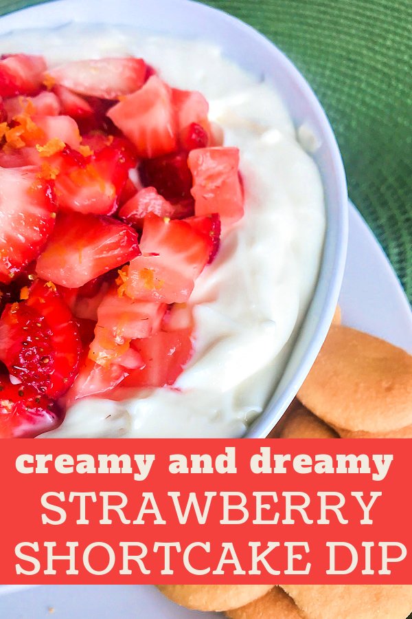 A bowl full of cream cheese dip with diced strawberries on top. 