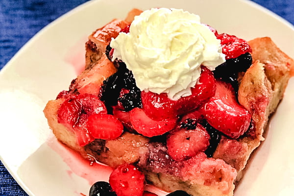 A square of french toast bake with fresh berries on top.