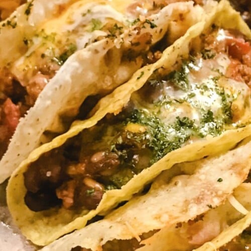 Baked beef and bean tacos on a sheet pan side by side.