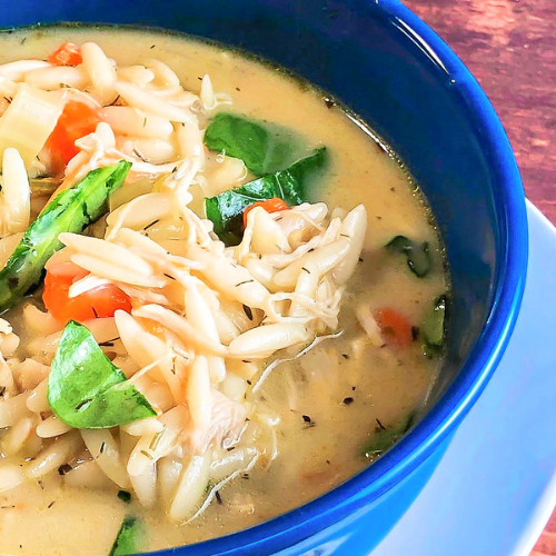 Easy lemon chicken orzo soup in a blue bowl with garnish
