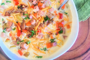 A white bowl brimming with Ham and Corn Chowder.