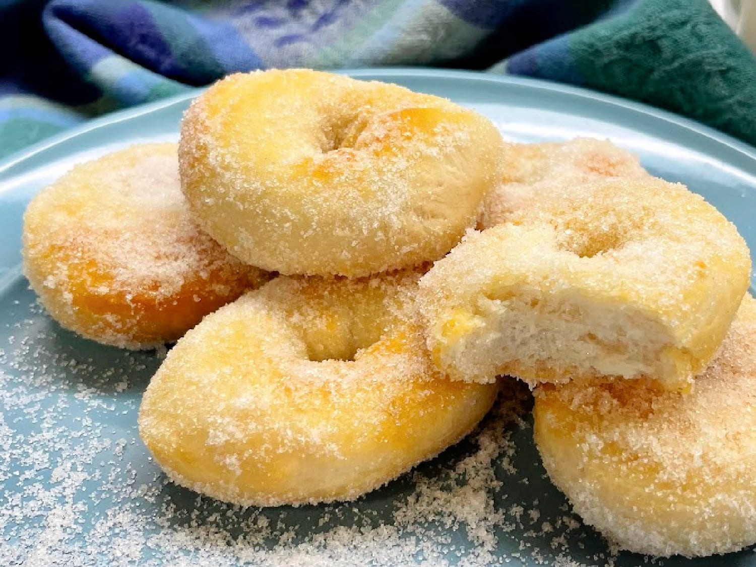 A stack of air fryer sugar doughnuts on a blue plate. 