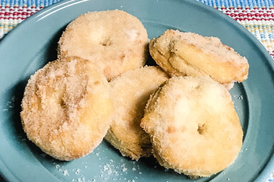 Air Fryer Sugar Doughnuts stacked up on a blue plate. 
